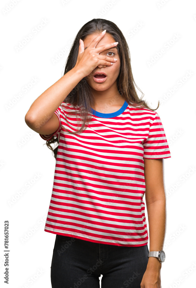 Poster Young beautiful arab woman over isolated background peeking in shock covering face and eyes with hand, looking through fingers with embarrassed expression.