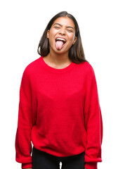 Young beautiful arab woman wearing winter sweater over isolated background sticking tongue out happy with funny expression. Emotion concept.