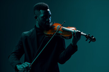 Elegant man in black suit playing the violin on dark background in atmospheric setting