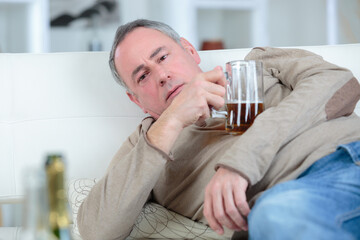mature drunk man holding a glass of beer - obrazy, fototapety, plakaty