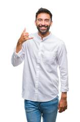 Adult hispanic man over isolated background smiling doing phone gesture with hand and fingers like talking on the telephone. Communicating concepts.
