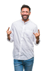 Fototapeta premium Adult hispanic man over isolated background shouting with crazy expression doing rock symbol with hands up. Music star. Heavy concept.