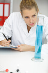 female lab worker analyzing pipette - obrazy, fototapety, plakaty