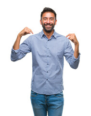 Adult hispanic man over isolated background looking confident with smile on face, pointing oneself...