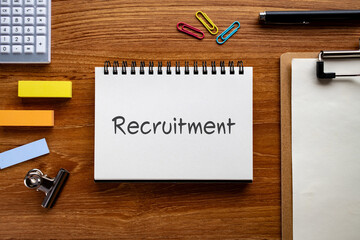 There is notebook with the word Recruitment. It is as an eye-catching image.