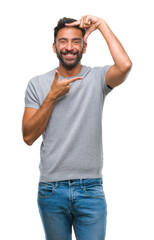 Adult hispanic man over isolated background smiling making frame with hands and fingers with happy face. Creativity and photography concept.