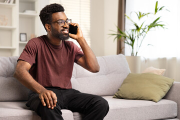 Happy African American Man Talking On Phone At Home. Cheerful Black Male In Casuals Engaging In Conversation, Comfort, Connectivity Concept. Relaxed Communication, Enjoying Weekend, Modern Living.
