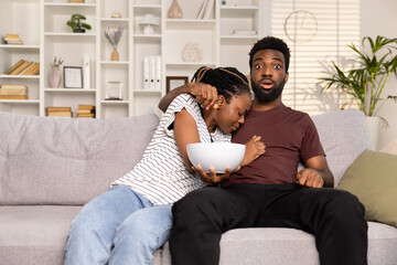 Surprised Man And Worried Woman Watching TV, Home Entertainment Shock, Indoor Relaxation, Modern Living Room, African American Couple, Leisure Time