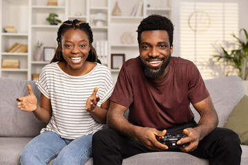 Happy Couple Enjoying Video Games Together At Home. Joyful Man And Woman With Game Controller, Casual Clothing, Excitement, Leisure Activity, Gaming Challenge. - Powered by Adobe