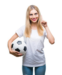 Young beautiful blonde woman holding soccer ball over isolated background surprised with an idea or...