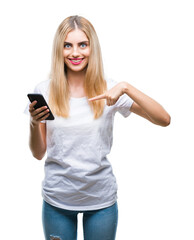 Fototapeta premium Young beautiful blonde woman using smartphone over isolated background with surprise face pointing finger to himself