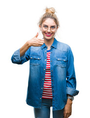 Young beautiful blonde woman wearing glasses over isolated background doing happy thumbs up gesture...