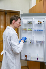 Scientist is taking samples from the fridge