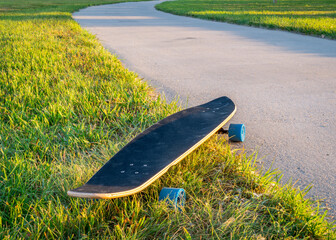 cruising longboard with blue wheels on a paved bike trail in summer scenery in northern Colorado