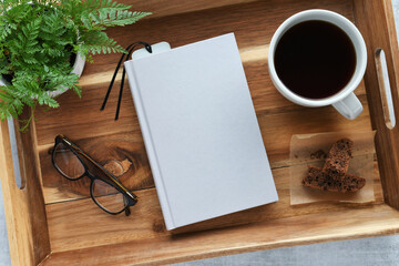 Blank 5.5x8.5 book cover for mock up with coffee, plant and reading glasses on a tray