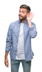 Young handsome man wearing white t-shirt over isolated background smiling with hand over ear...