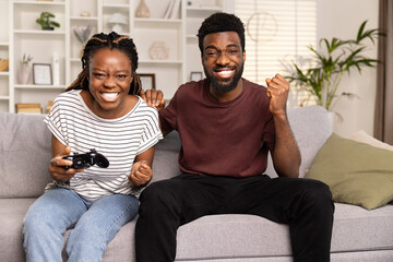 Couple Enjoying Video Game Together On Couch At Home, Competitive Fun, Leisure Activity - obrazy, fototapety, plakaty
