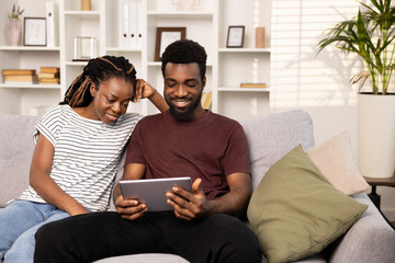 Couple Enjoying Time Together With Tablet On Couch