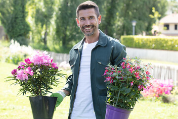 portrait of a handsome gardener with flowers - obrazy, fototapety, plakaty