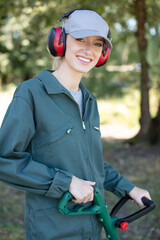 happy blond woman with hat gardening - obrazy, fototapety, plakaty