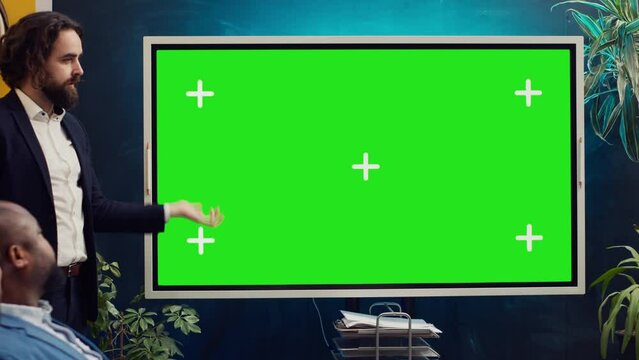 Startup team using greenscreen interactive board in a strategy workshop meeting, working together to improve their skills and performance. Corporation employees prepare for collaboration. Camera A.