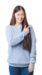 Young Chinese woman over isolated background cheerful with a smile of face pointing with hand and finger up to the side with happy and natural expression on face looking at the camera.