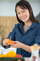 a happy woman cutting carrots