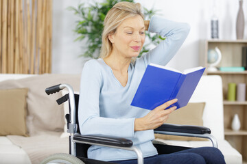 senior woman with disability recovery at home wheelchair reading book