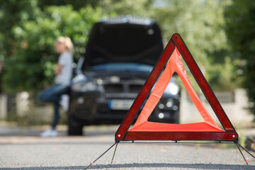 warning triangle behind his broken car - obrazy, fototapety, plakaty