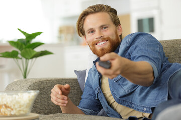man smiling holding remote control - 781665638