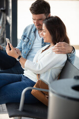happy couple enjoying media content in a smart phone - obrazy, fototapety, plakaty