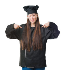 Young Chinese woman over isolated background wearing chef uniform looking confident with smile on face, pointing oneself with fingers proud and happy.