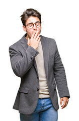Young business man wearing glasses over isolated background bored yawning tired covering mouth with hand. Restless and sleepiness.