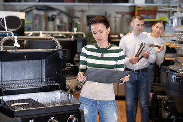 Woman looking at bbq grill in showroom