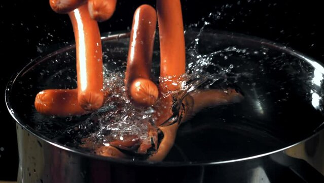Super slow motion sausages fall into a pot. High quality FullHD footage