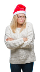 Young caucasian woman wearing christmas hat over isolated background skeptic and nervous, disapproving expression on face with crossed arms. Negative person.