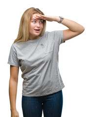 Fototapeta premium Young caucasian woman over isolated background very happy and smiling looking far away with hand over head. Searching concept.