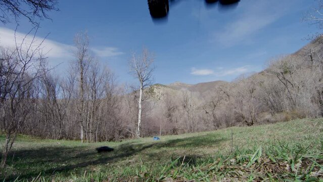 RC car flying over camera and racing in field - low, wide shot
