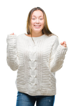 Young beautiful caucasian woman wearing winter sweater over isolated background celebrating surprised and amazed for success with arms raised and open eyes. Winner concept.