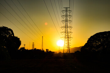 A sunset over a field with power lines in the background
