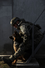 Ukrainian soldier with German shepherd dog sitting outdoors