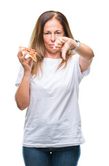 Middle age hispanic woman eating pizza slice over isolated background with angry face, negative sign showing dislike with thumbs down, rejection concept