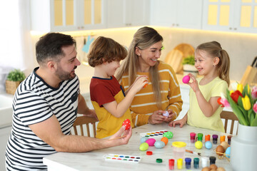 Happy Easter. Cute family with painted eggs at white marble table in kitchen