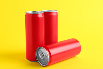 Energy drinks in red cans on yellow background