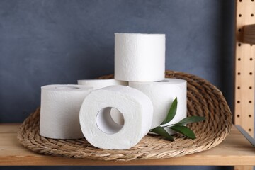 Toilet paper rolls and green leaves on wooden shelf