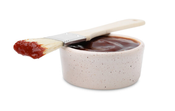 Marinade in bowl and basting brush isolated on white
