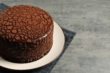 Delicious chocolate truffle cake on grey textured table, space for text