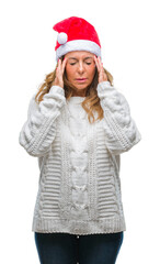 Middle age senior hispanic woman wearing christmas hat over isolated background with hand on head for pain in head because stress. Suffering migraine.