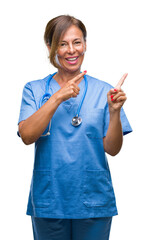 Middle age senior nurse doctor woman over isolated background smiling and looking at the camera pointing with two hands and fingers to the side.