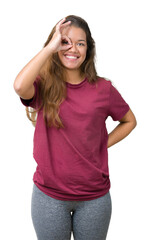 Fototapeta premium Young beautiful brunette woman over isolated background doing ok gesture with hand smiling, eye looking through fingers with happy face.